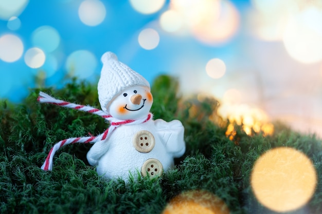 Kleiner Schneemann auf blauem Hintergrund mit Bokeh