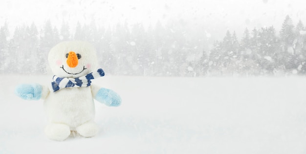Kleiner Schneemann auf einem Winterhintergrund mit Kopienraum. Weihnachtshintergrund. Neujahrskarte. Banner.