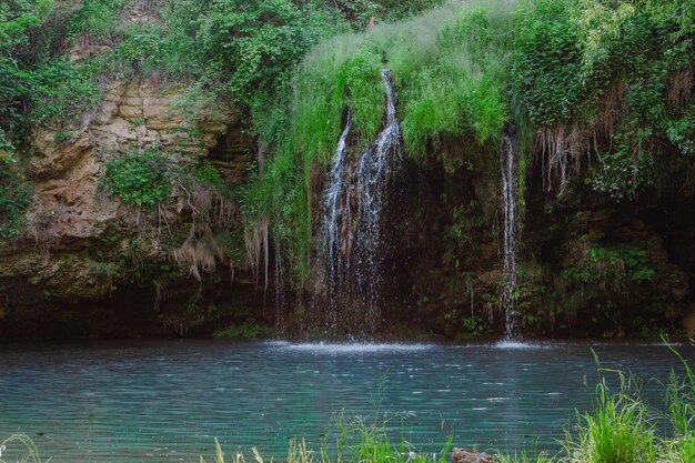 Kleiner schöner Wasserfall mit Kopienraum des blauen Sees