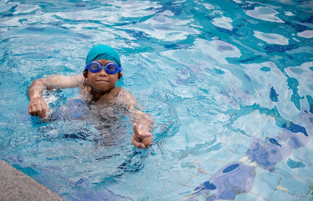 Kleiner süßer Junge, der im Pool schwimmt