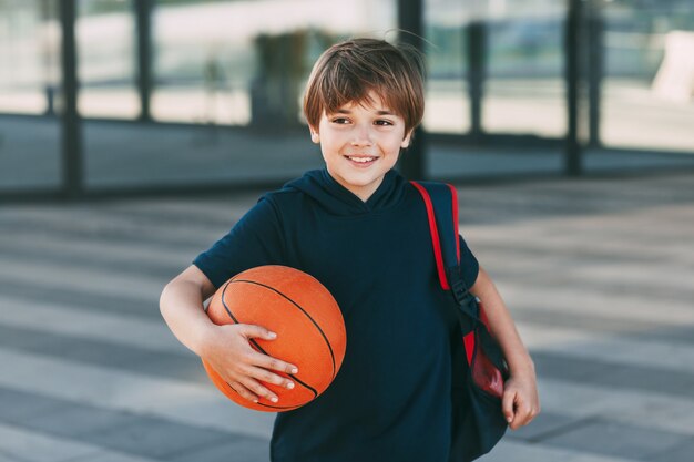 Foto kleiner süßer junge mit einem basketballball