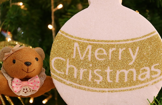 Kleiner Teddybär mit goldener und weißer Weihnachtsverzierung