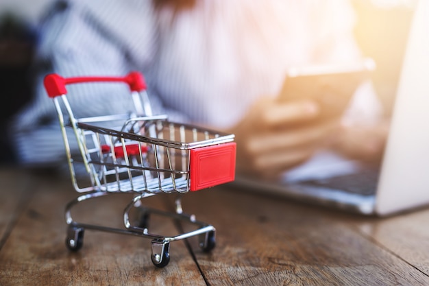 Kleiner Trolley mit jungen Frauen nutzen Smartphone und Laptop.