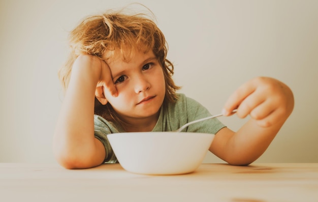 Kleiner unzufriedener Junge will keine Nudeln mit Kotelett essen Kleiner Junge will nicht essen