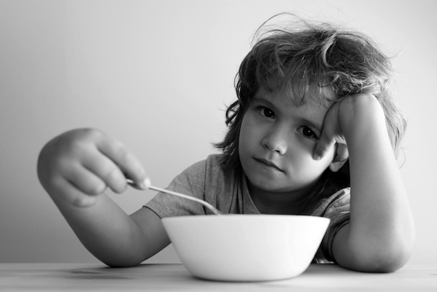 Kleiner unzufriedener Junge will keine Nudeln mit Kotelett essen Kleiner Junge will nicht essen