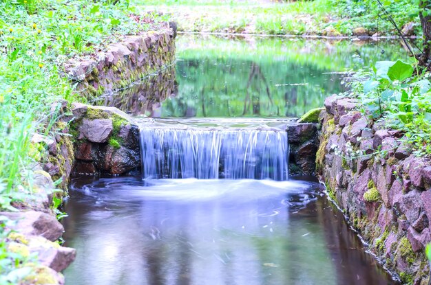 Kleiner Wasserfall an einem kleinen malerischen Bach im Wald