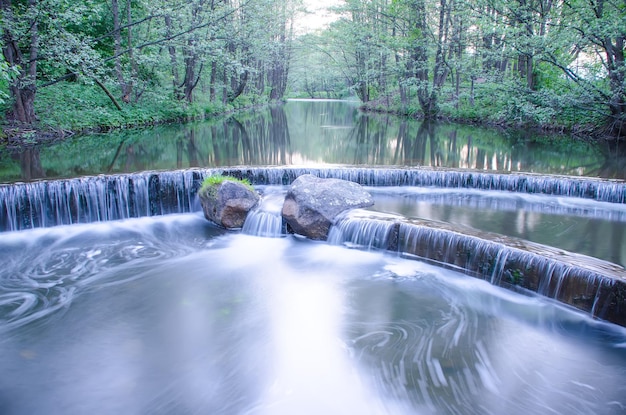 Kleiner Wasserfall an einem kleinen malerischen Bach im Wald