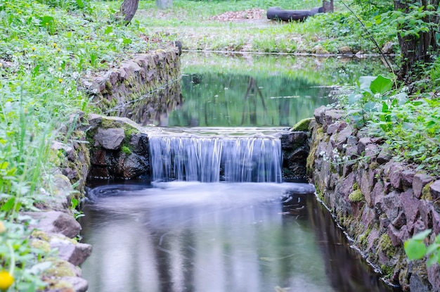 Kleiner Wasserfall an einem kleinen malerischen Bach im Wald