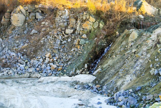 Kleiner Wasserfall im Steinbruch im Herbst