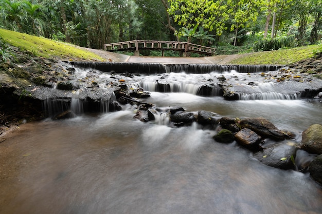 Kleiner Wasserfall mit alter Holzbrücke