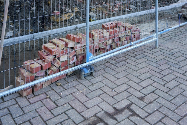 Kleiner Ziegelhaufen hinter Stahlzäunen auf der Baustelle