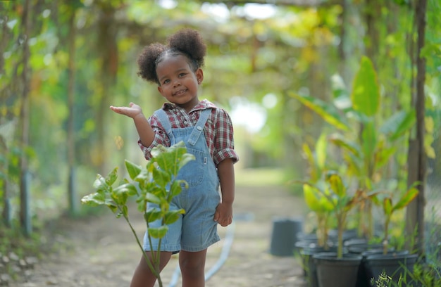 Kleines Afro-Mädchen mit Outdoor-Aktivitäten auf dem Bauernhof Bio-Garten diverses Familienkind Muttertagskonzept