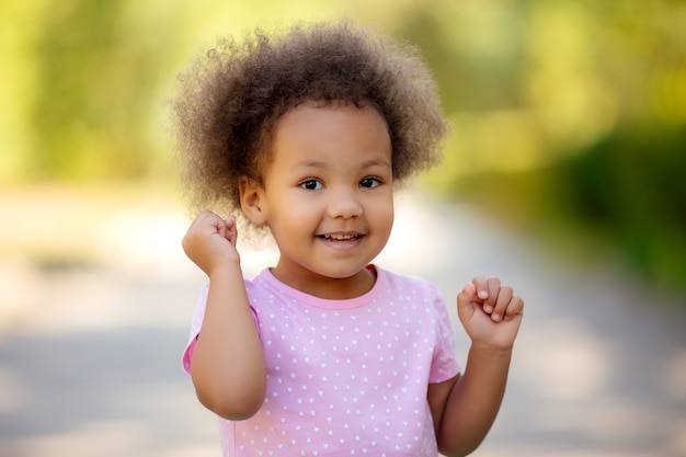 Kleines Afroamerikanermädchen im Sommer auf einem Weg