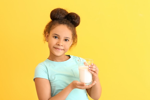 Kleines afroamerikanisches Mädchen mit Milch auf Farbe