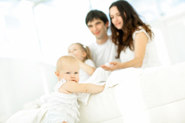 Kleines Baby auf unscharfem Hintergrund der Familie. Foto mit Kopienraum. Das Konzept der Elternschaft