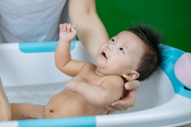 Kleines Baby, das auf Mutterhänden badet