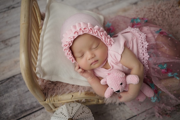 Kleines Baby, eingehüllt in rosa Kleidung mit einem Verband auf dem Kopf, schläft auf weißem Kissen