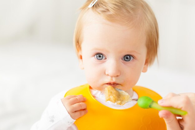 Foto kleines baby füttert mit einem löffel