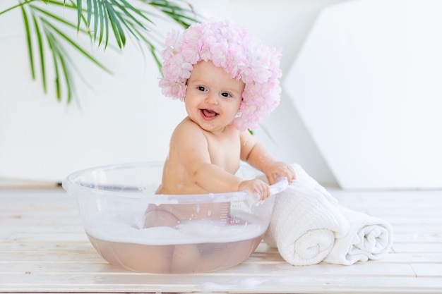 Kleines Baby in einem Becken mit Schaum und Wasser