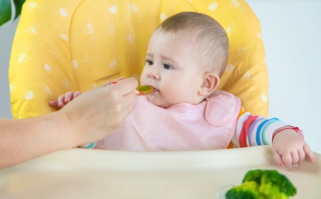 Kleines Baby isst Brokkoli-Gemüsepüree. Selektiver Fokus. Menschen.