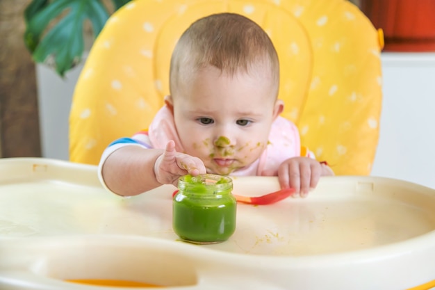 Kleines Baby isst Brokkoli-Gemüsepüree. Selektiver Fokus. Menschen.