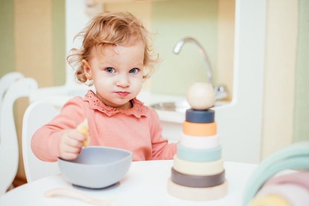 Kleines Baby isst Nudeln in der Kinderküche