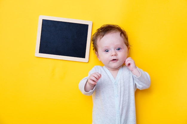 Kleines Baby mit schwarzer Tafel