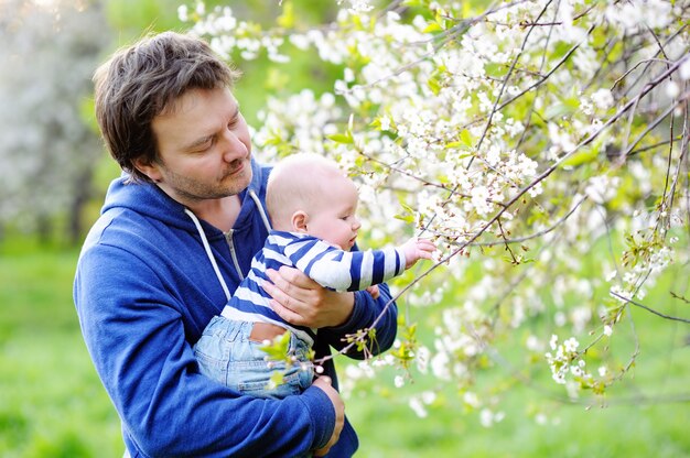 Kleines Baby mit seinem Mittelaltervater im Blütengarten