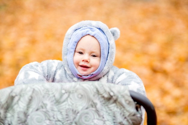 Kleines Baby spielt im Herbstpark Kleines Mädchen mit Eichen- und Ahornblatt-Herbstlaub
