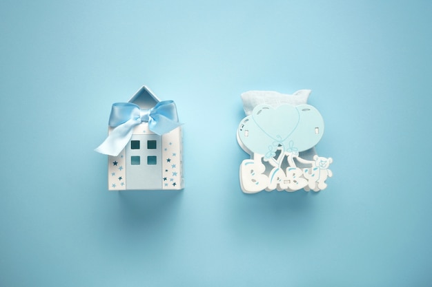 Kleines blaues Papierhaus als Playneck und hölzernes Spielzeug des Kindes mit Ballonen auf dem blauen Hintergrund