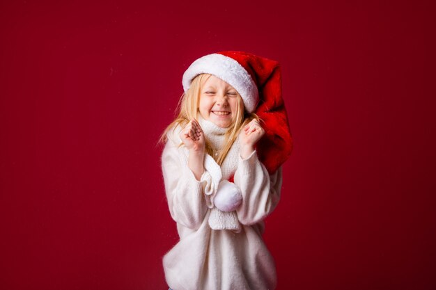 Kleines blondes Mädchen im Weihnachtsmannanzug