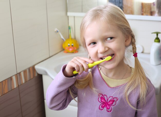 Kleines blondes Mädchen mit Zahnbürste