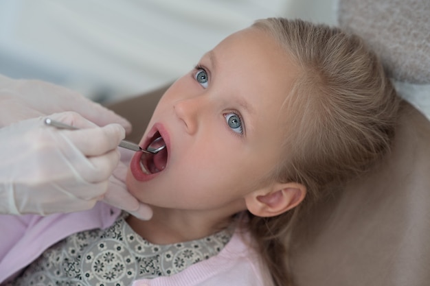 Kleines blondes Mädchen wird vom Kinderarzt untersucht