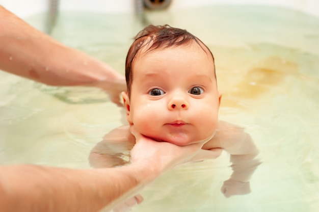 Kleines charmantes Mädchen badet in warmem Wasser