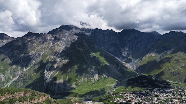 Kleines Dorf vor großen grünen Bergen