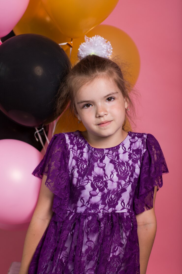 Kleines dunkelhaariges Mädchen mit bunten Ballonen