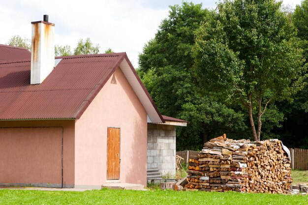 Kleines Einfamilienhaus mit Brennholz draußen