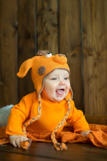 Kleines europäisches Baby in leuchtend orangefarbenen Kleidern