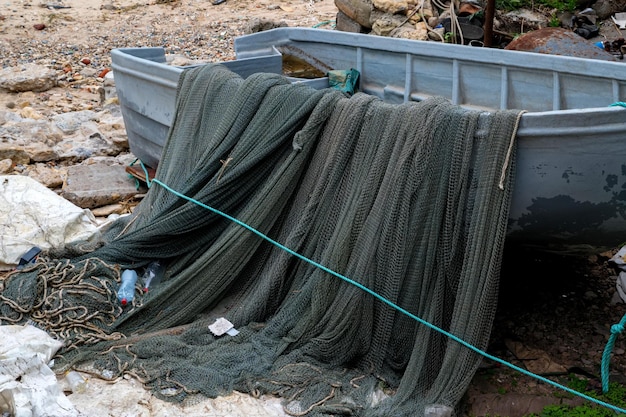 Kleines Fischerboot mit Netz am Ufer