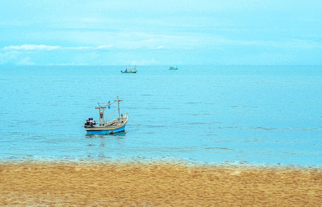 Kleines Fischerboot schwimmend im blauen Meer mit blauem Himmel Thailand Fischerboot oder Fischerboot oder Schiff auf Sam Roi Yod Bech Prachuap Khiri Khan Thailand mit blauem Himmel und Wolken und blauem Meer