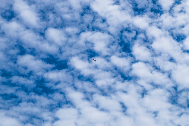 Kleines Flugzeug fliegt in den blauen Himmel zwischen weißen Wolken und Sonnenlicht. Flugzeugzielhintergrund. Abenteuerzeit Konzept. verlorene und gefundene Konzeptidee