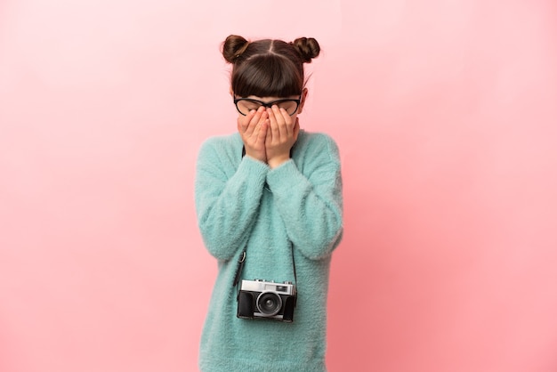 Kleines Fotografmädchen lokalisiert auf Rosa mit müde und krankem Ausdruck