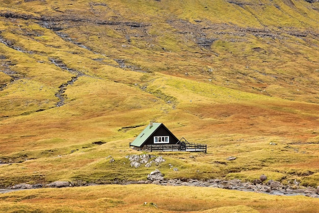 kleines Haus steht in einem erstaunlichen Herbsttal Färöer-Inseln