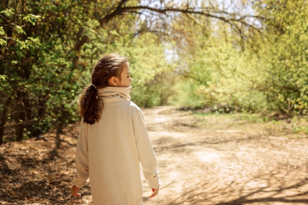 Kleines hübsches Mädchen auf Spaziergang im sonnigen Frühlingspark Märchenwald