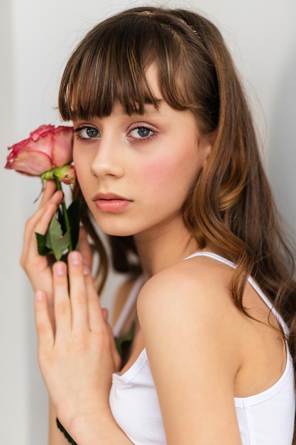 Kleines hübsches Mädchen in Rosa hält den Strauß Rosen. Schließen Sie die Blumen und stellen Sie sich der kleinen Ballerina mit einem Strauß gegenüber