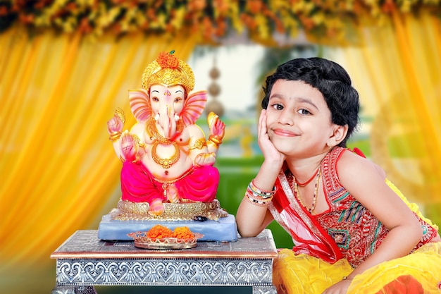 Kleines indisches Mädchen mit Lord Ganesha und dem Beten, indisches Ganesh-Festival