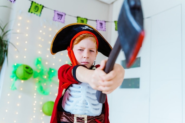 Kleines kaukasisches Kind, das mit Halloween-Piratenkostüm zu Hause spielt