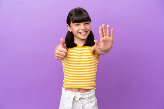 Kleines kaukasisches Kind isoliert auf violettem Hintergrund, das sechs mit den Fingern zählt