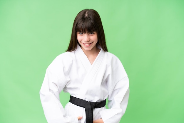 Kleines kaukasisches Mädchen, das Karate vor isoliertem Hintergrund macht, lacht