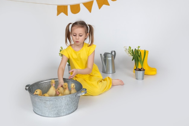 Kleines kaukasisches Mädchen im Vorschulalter, das ein süßes Entlein in den Händen hält